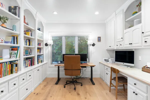 a view of a hallway with wooden floor and a living room