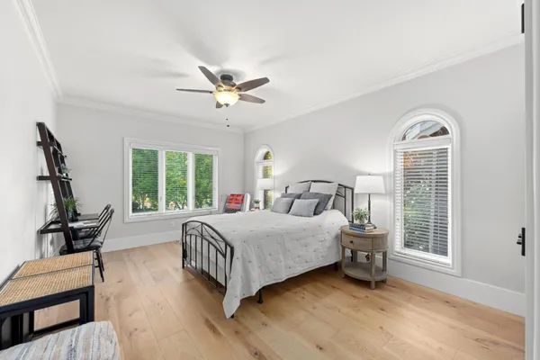 a spacious bedroom with a bed and ceiling fan