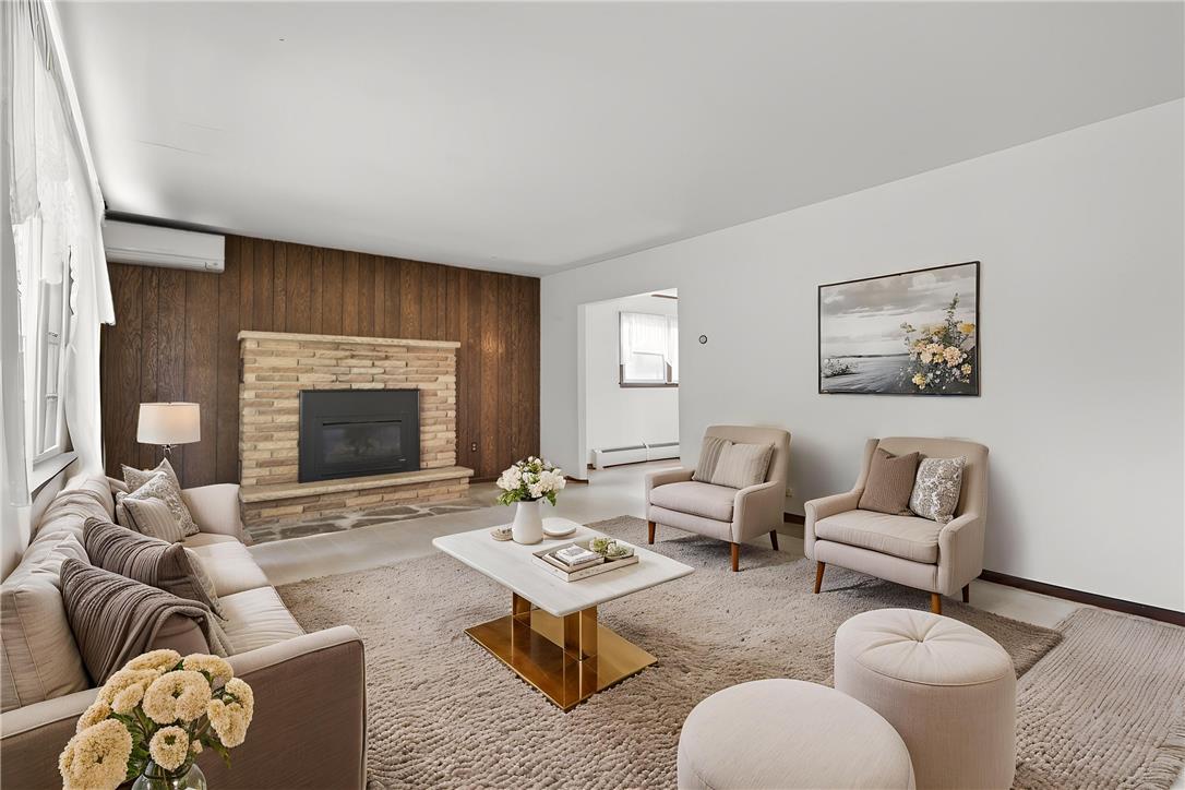 62 Stoney Road Tamaqua, PA 18252 - Photo 6 of 61 A cozy living room features a classic brick fireplace and warm wood paneling, perfect for intimate gatherings.