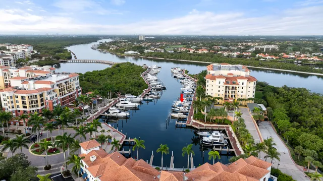 an aerial view of a city with lots of residential buildings ocean and mountain view in back