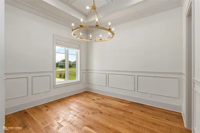 an empty room with wooden floor cabinet and windows