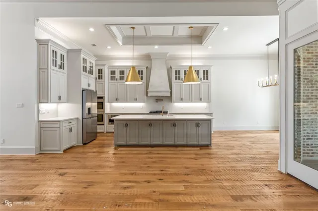 a room with kitchen island stainless steel appliances a couch window and cabinets