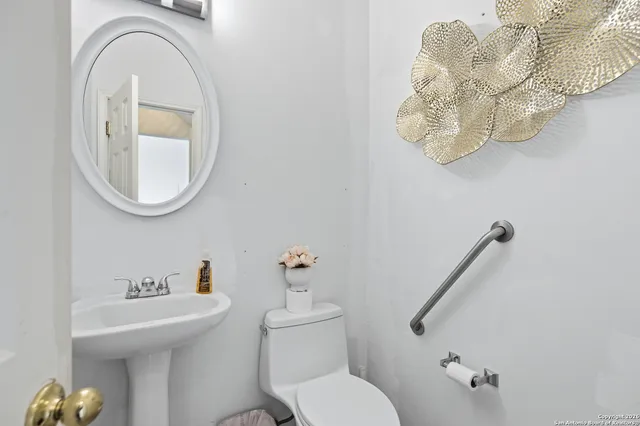a bathroom with a toilet sink and mirror
