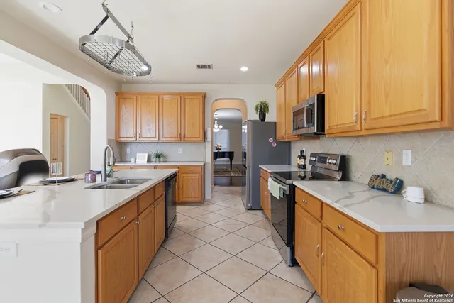 a kitchen with stainless steel appliances granite countertop a sink a stove and cabinets