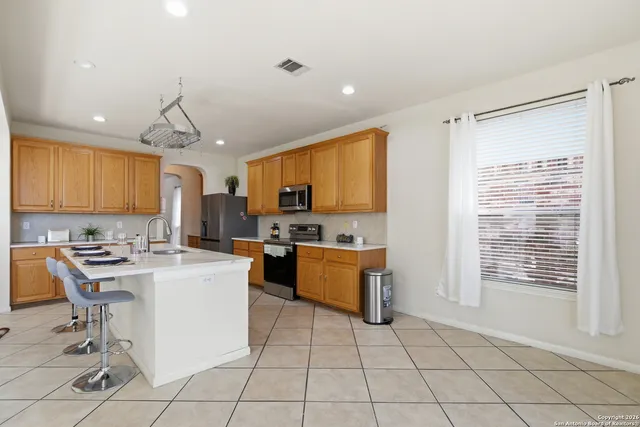 a kitchen with a sink a counter top space cabinets and stainless steel appliances