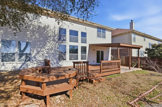 a front view of a house with a yard and wooden bench