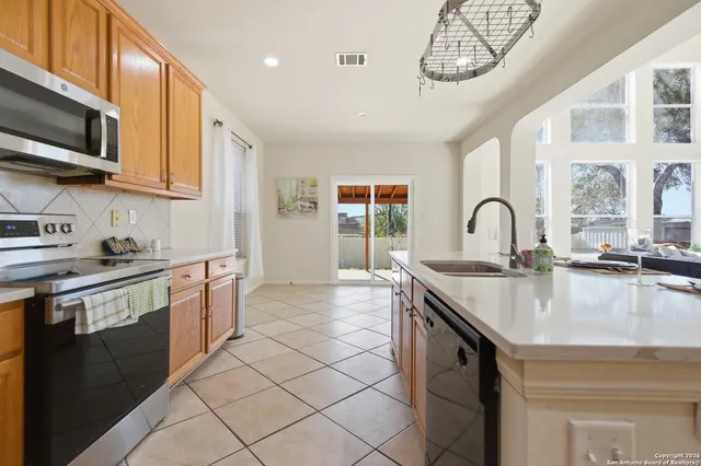 a kitchen with stainless steel appliances granite countertop a sink a stove and a microwave