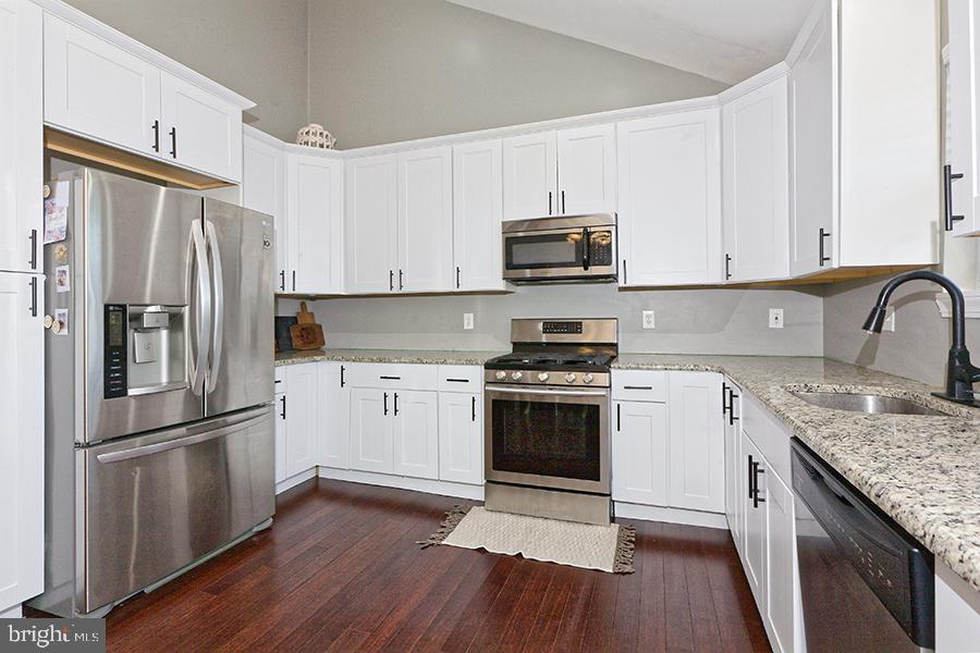 1044 Center Street Tuckerton, NJ 08087 - Photo 16 of 27 a kitchen with granite countertop a refrigerator stove and sink with wooden floor