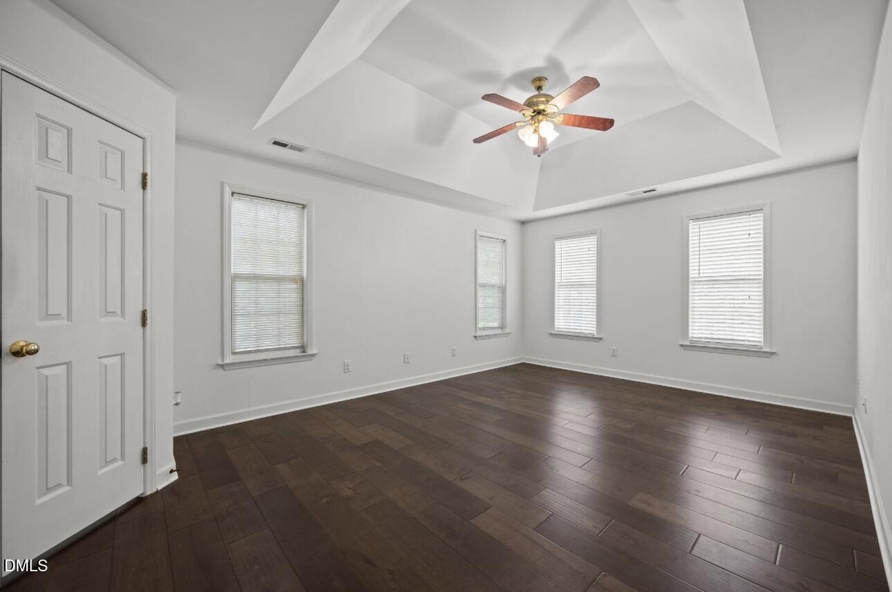 3616 Dewing Drive Raleigh, NC 27616 - Photo 13 of 25 an empty room with wooden floor chandelier fan and windows
