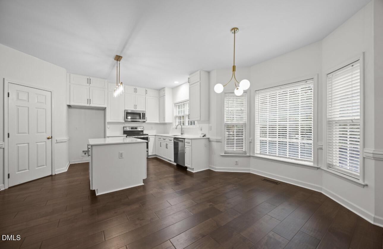 3616 Dewing Drive Raleigh, NC 27616 - Photo 5 of 25 a open kitchen with white cabinets and wooden floor