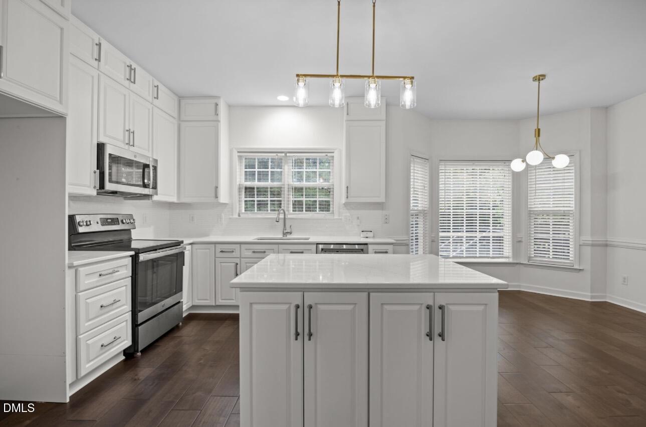 3616 Dewing Drive Raleigh, NC 27616 - Photo 7 of 25 a kitchen with stainless steel appliances granite countertop a stove a sink dishwasher a refrigerator and white cabinets with wooden floor