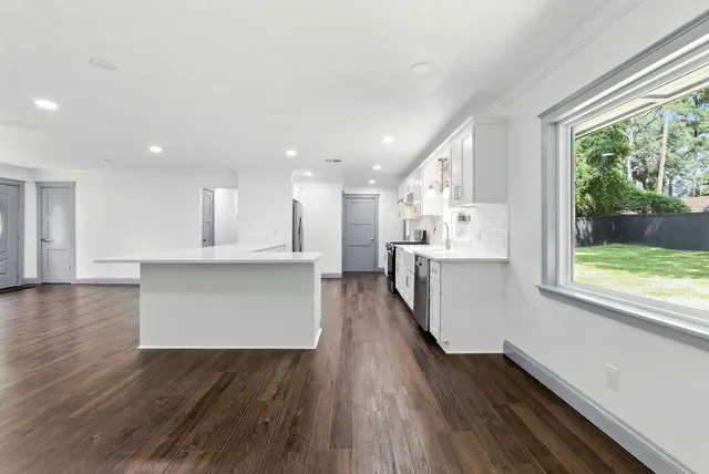 a large kitchen with kitchen island a sink stainless steel appliances and cabinets