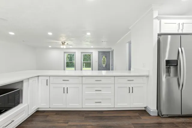 a large kitchen with stainless steel appliances granite countertop a lot of counter space and wooden floors