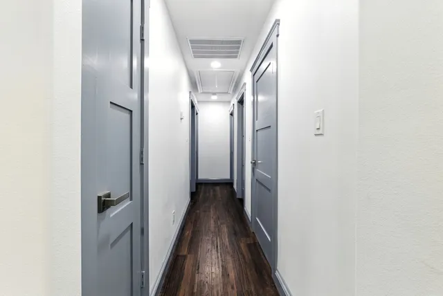 an empty room with wooden floor ceiling fan and window