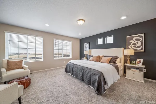 a spacious bedroom with a bed and glass window