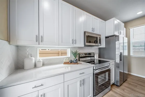 a kitchen with appliances a sink and cabinets