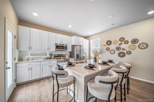 a kitchen with a dining table chairs sink and microwave