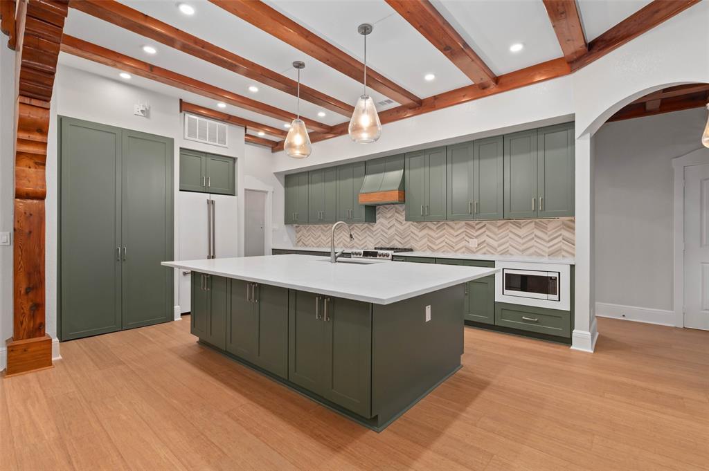 124 Garza Road Shady Shores, TX 76208 - Photo 11 of 40 Chef's kitchen with oversized island and breakfast bar, induction cooktop, double ovens with convection, microwave with convection and quartz countertops