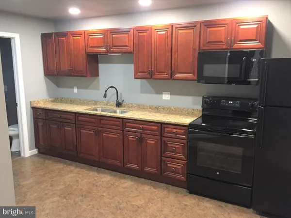 a kitchen with granite countertop wooden cabinets and stainless steel appliances