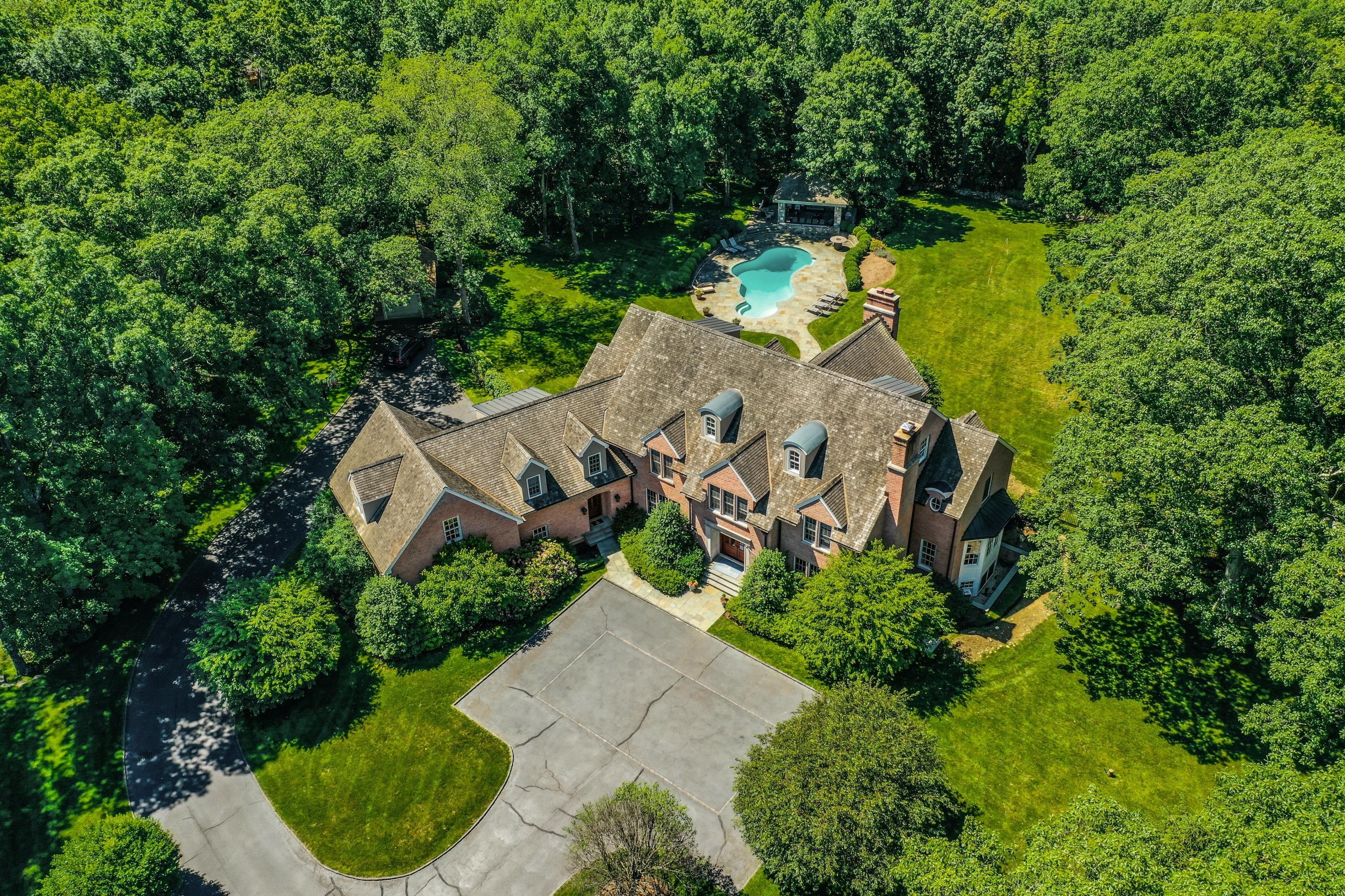 an aerial view of a house with a yard and lake view
