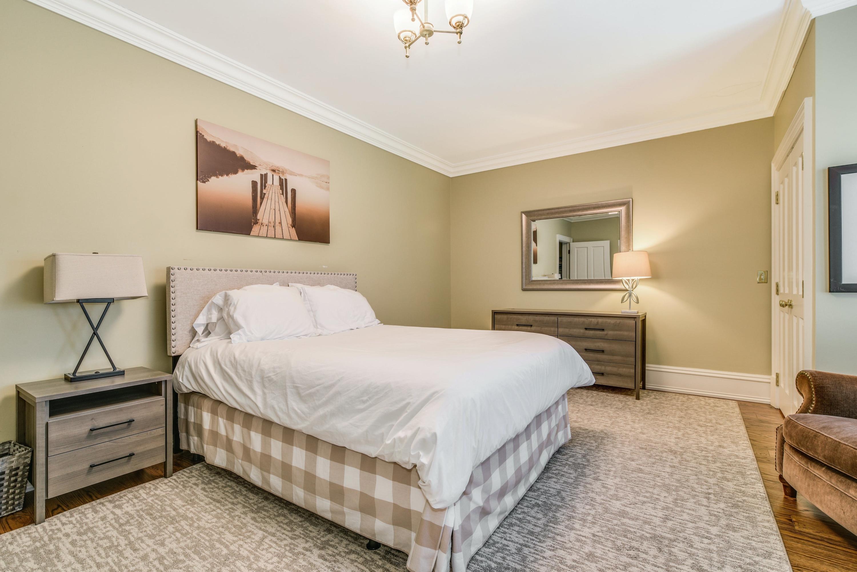 910 Smith Ridge Road New Canaan, CT 06840 - Photo 20 of 40 a bedroom with a bed and a chandelier