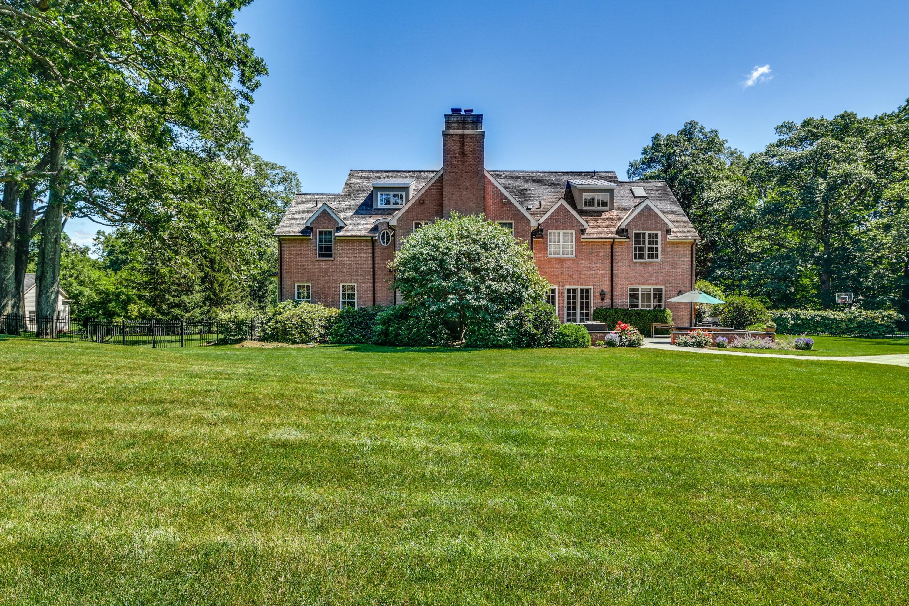 910 Smith Ridge Road New Canaan, CT 06840 - Photo 33 of 40 a front view of a house with a yard