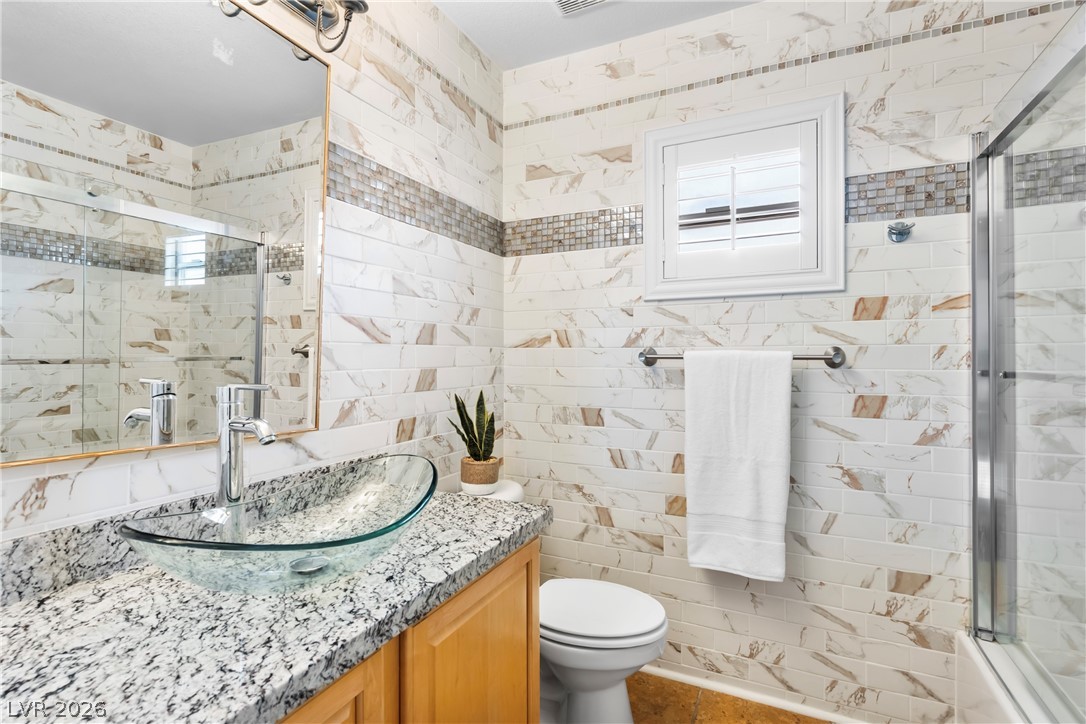 708 Vortex Avenue Henderson, NV 89002 - Photo 41 of 71 Marble-tiled walls and a sleek vessel sink define this polished primary bathroom.