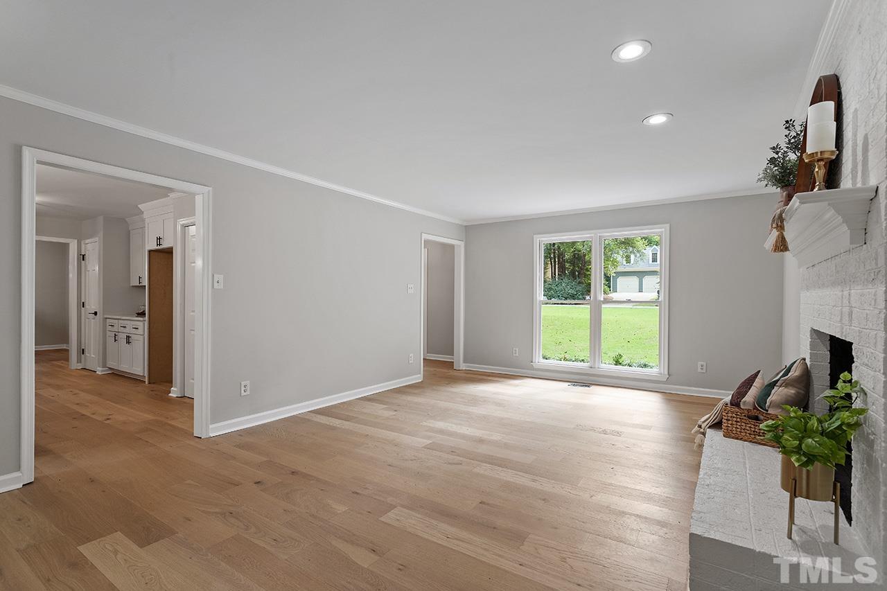 8805 Wellsley Way Raleigh, NC 27613 - Photo 11 of 39 a view of an empty room with a fireplace and a window
