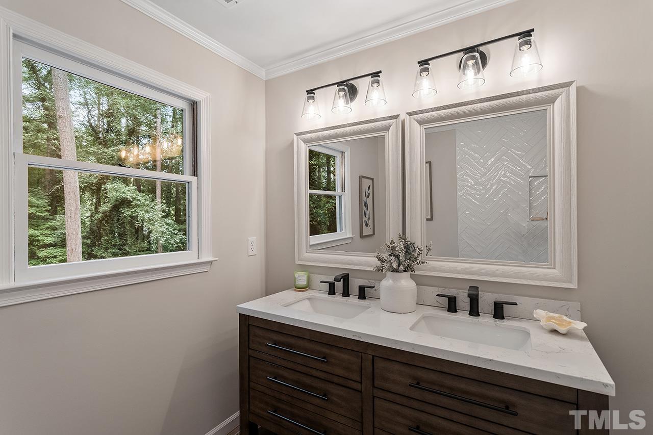 8805 Wellsley Way Raleigh, NC 27613 - Photo 26 of 39 a bathroom with a granite countertop sink a mirror and a window