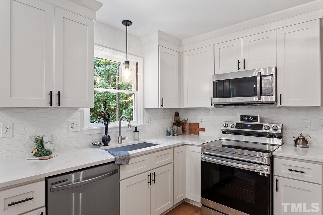 8805 Wellsley Way Raleigh, NC 27613 - Photo 5 of 39 a kitchen with stainless steel appliances white cabinets and a stove top oven