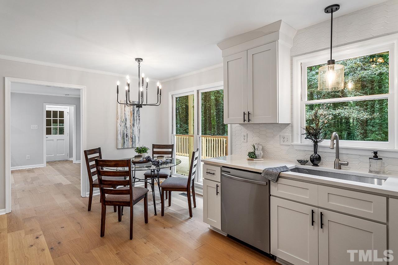 8805 Wellsley Way Raleigh, NC 27613 - Photo 6 of 39 a kitchen that has a cabinets counter space dining table and a large window