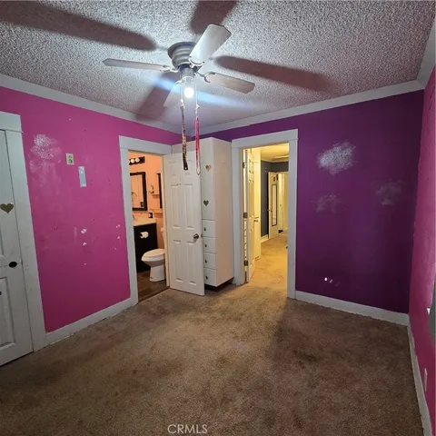 a view of a livingroom with a chandelier fan and a window