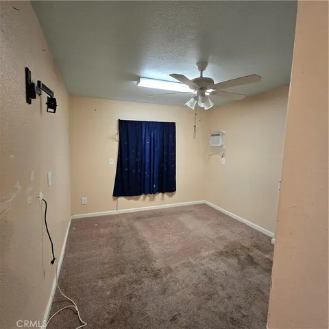 an empty room with windows and fan