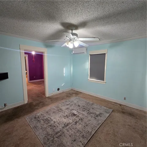a view of a livingroom with a chandelier fan and windows