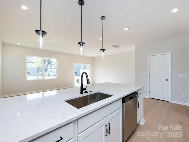 a kitchen with stainless steel appliances kitchen island a sink a counter space and a window
