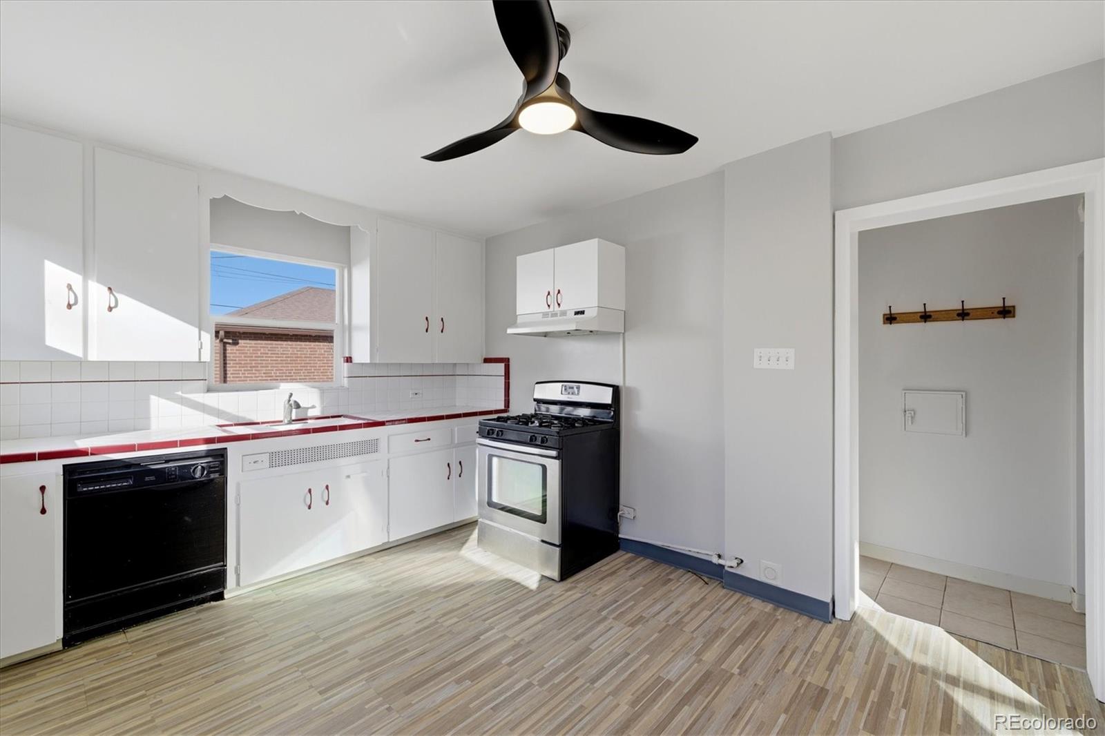 2053 Quitman Street Denver, CO 80212 - Photo 13 of 39 a kitchen with stainless steel appliances granite countertop a sink and stove top oven