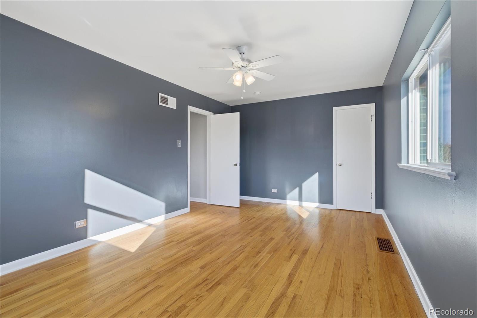 2053 Quitman Street Denver, CO 80212 - Photo 27 of 39 a view of a big room with wooden floor and a ceiling fan