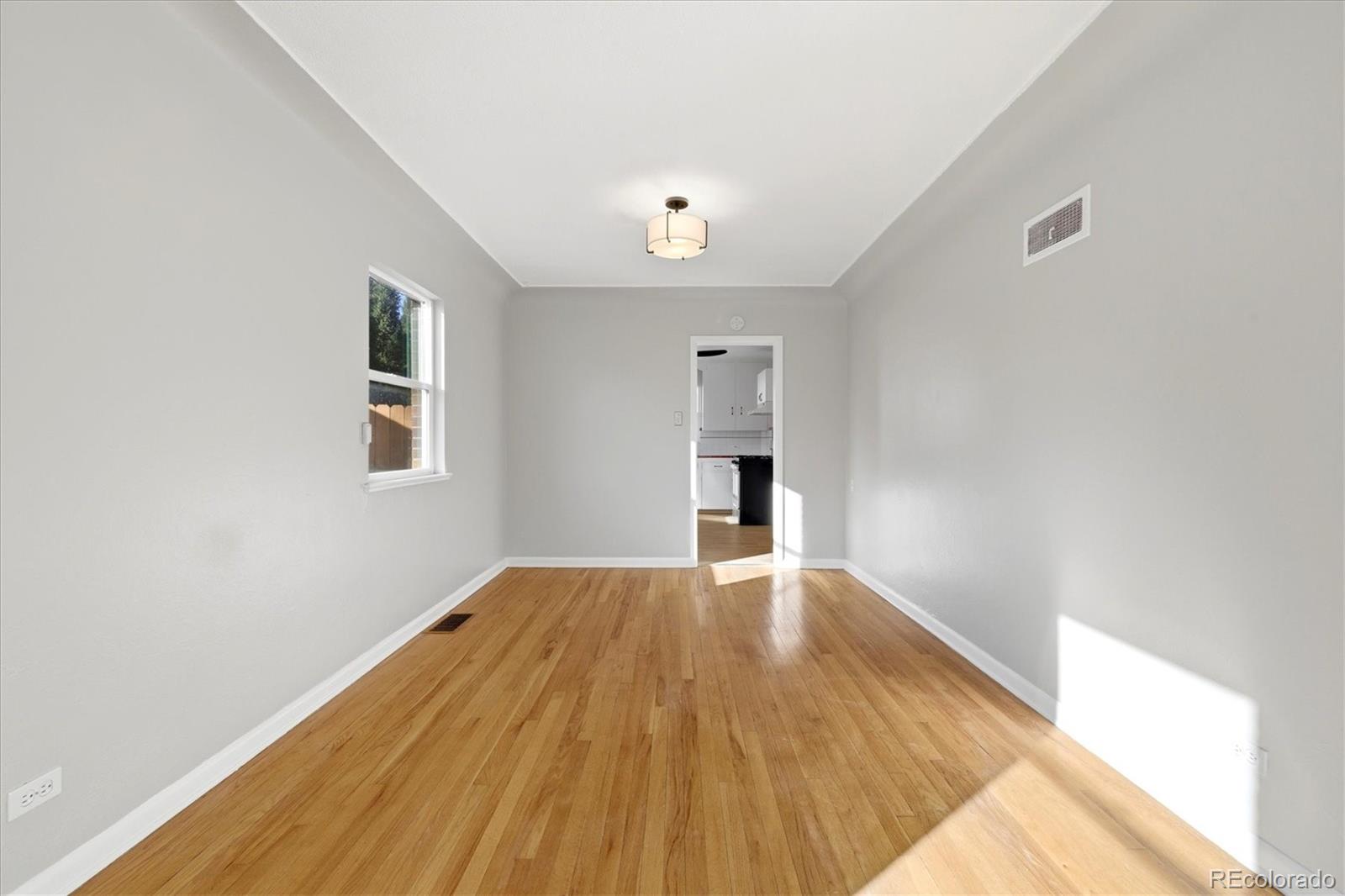 2053 Quitman Street Denver, CO 80212 - Photo 10 of 39 a view of an empty room with wooden floor and a window