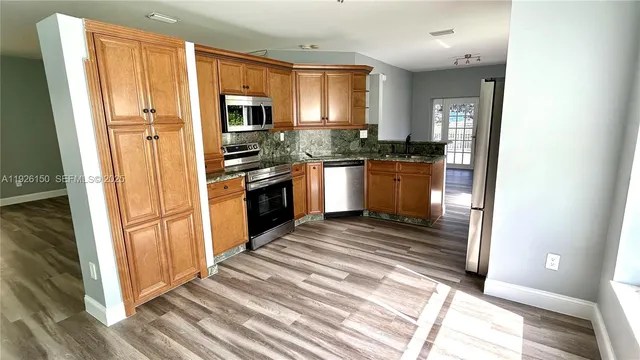 a bathroom with a granite countertop sink and a large mirror