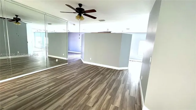 a view of entryway and bedroom with wooden floor