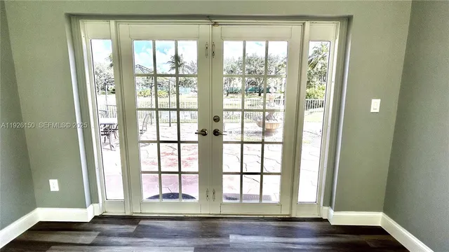 a view of a hallway with wooden floor and a living room