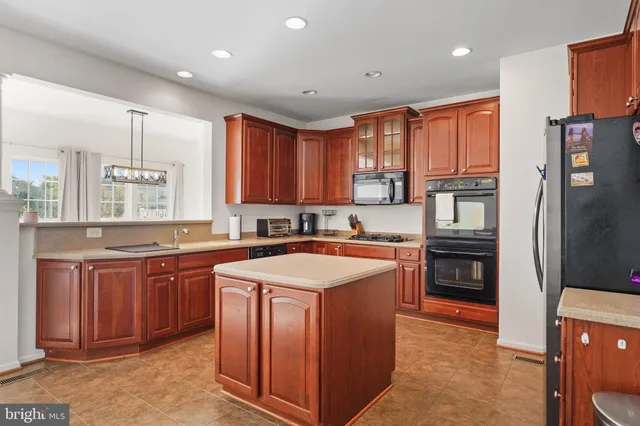 a kitchen with stainless steel appliances granite countertop a stove a sink dishwasher a refrigerator and a oven