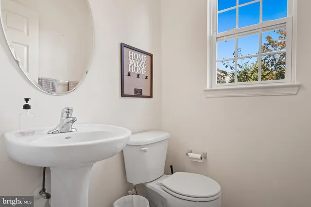a bathroom with a toilet a sink and a mirror