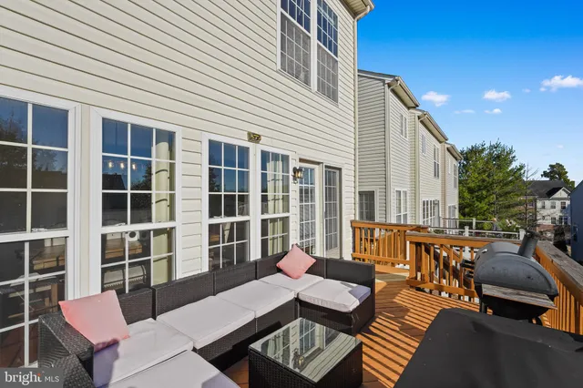 a balcony with couches and a potted plant on a table
