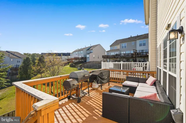 a view of a patio with couches chairs and wooden floor