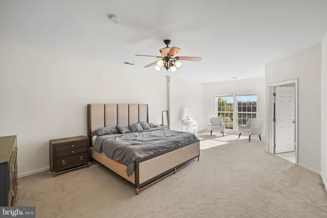 a spacious bedroom with a bed and a chandelier