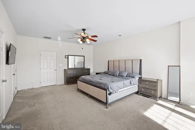 a spacious bedroom with a bed and a chandelier