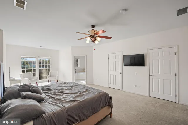 a spacious bedroom with a bed and a chandelier