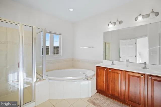 a bathroom with a tub sink and mirror