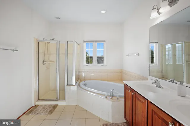 a bathroom with a tub sink and mirror